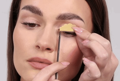 मॉडल धीरे से अपनी पलकों और पलकों से छड़ें हटा रही है